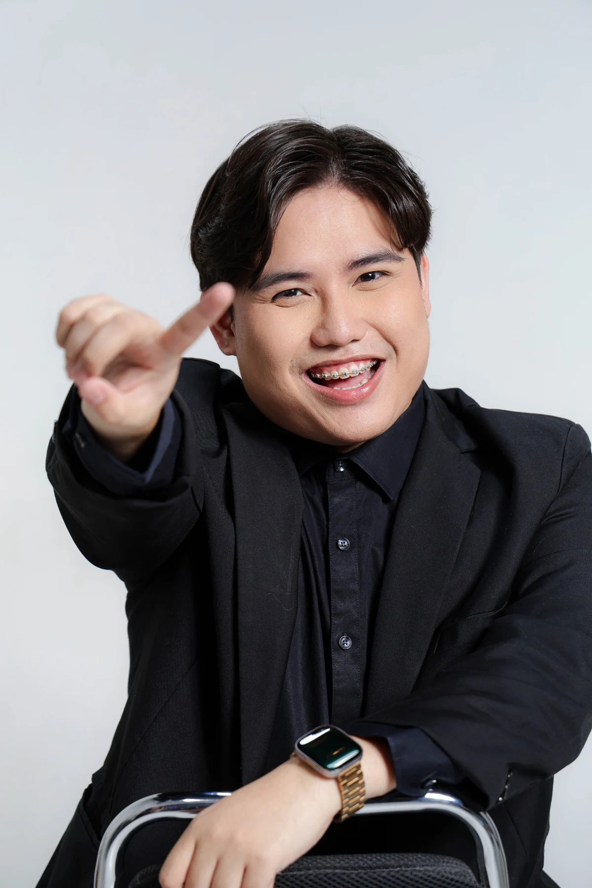 Brian Saludo smiling with a playful hand gesture toward the camera